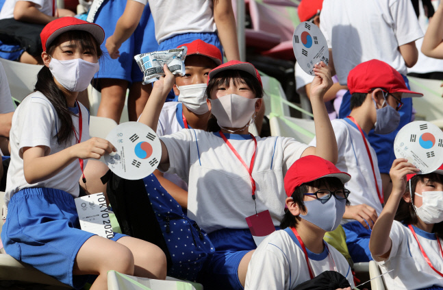 미카사 초등학교 학생들이 태극기가 그려진 부채를 흔들며 한국 선수들을 응원하고 있다. 경기가 열리는 가시마는 긴급 사태 지역에 포함되지 않아 관중이 들어올 수 있다. 사진| 연합뉴스