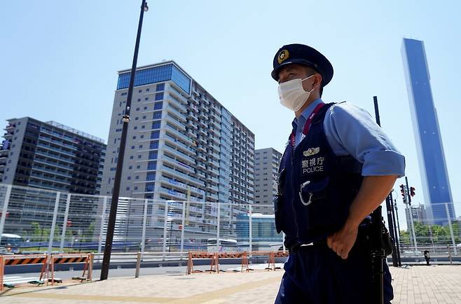 한 경찰관이 22일 일본 도쿄 올림픽 선수촌 앞을 지키고 서 있다. 도쿄/로이터 연합뉴스