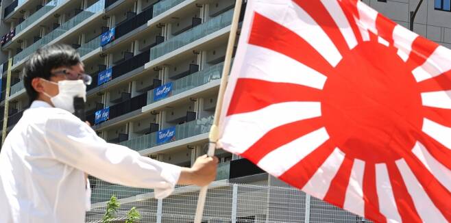 ▲ 일본 극우단체 관계자가 선수촌 앞에서 욱일기를 들고 시위하고 있다. ⓒ연합뉴스