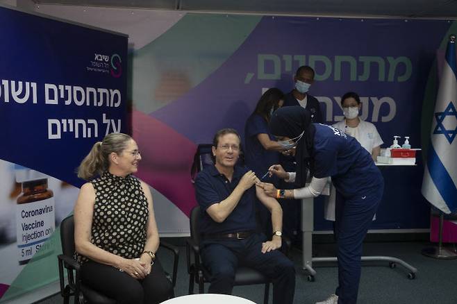 아이작 헤르조그 이스라엘 대통령(오른쪽)이 30일(현지시간) 서부 도시 라마트간의 한 병원에 코로나19 3차 백신(부스터 샷)을 맞고 있다.(사진=AP/연합뉴스)