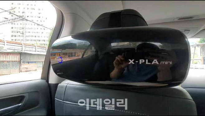 코비플라텍의 차량용 공기 살균·탈취기 ‘엑스플라 미니(X-PLA mini)’를 차내 헤드레스트에 설치한 모습.