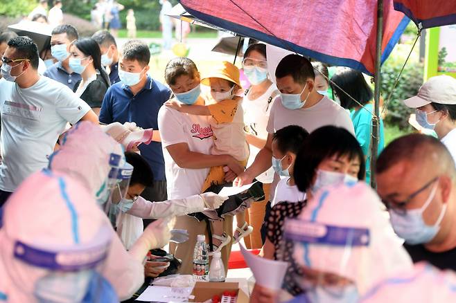 중국 우한에서 3일 마스크를 쓴 사람들이 코로나19 검사를 위해 줄 서 있다. [EPA]