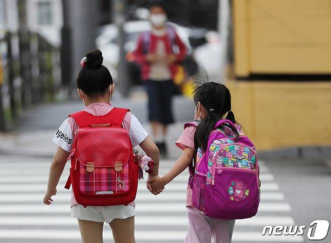 서울 한 초등학교에서 아이들이 손을 잡고 등교하고 있다.  2021.7.9/뉴스1 © News1 이성철 기자