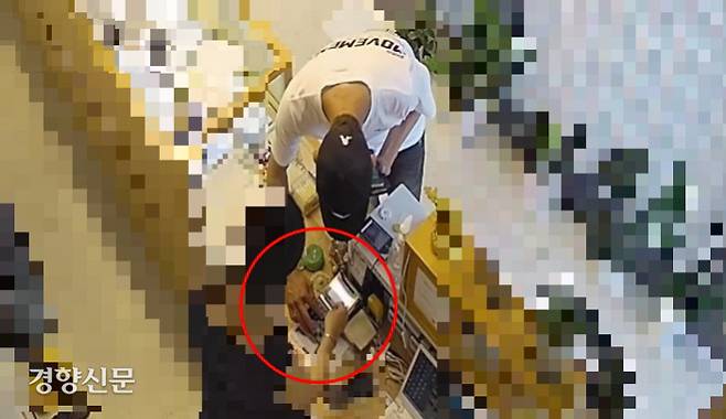 지난 7일 오후 4시50분쯤 서울 마포구의 한 귀금속 매장에 나타난 사기범(33)이 신용카드 결제단말기 포스를 조작하려고 손을 뻗은 모습. A씨 제공 CCTV 화면 캡처본