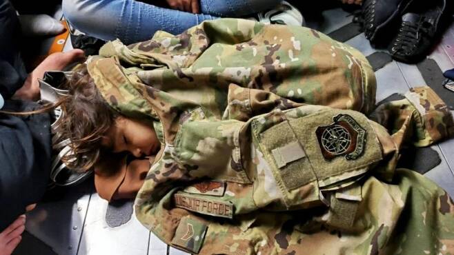 수송기 안에서 잠든 아이  군복을 덮고 잠든 아프간 아이. [로이터=연합뉴스]