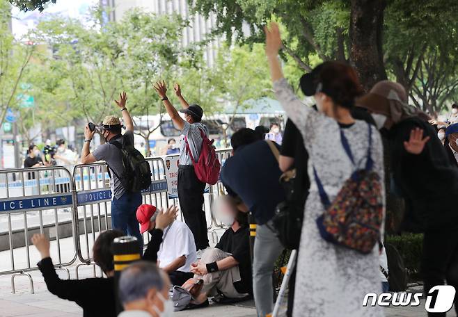 관할 구청에서 시설 폐쇄 결정이 내려진 서울 성북구 사랑제일교회가 광화문 광장에서 대변 예배를 강행한 22일 서울 광화문 일대에서 신도들이 유튜브로 예배를 드리고 있다. 2021.8.22/뉴스1 © News1 이성철 기자