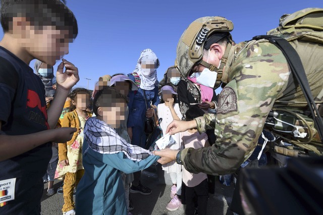 [서울=뉴시스] 공군 최정예 특수부대 요원인 공정통제사(CCT : Combat Control Team)가 25일(현지시간) 아프가니스탄 카불공항에서 한국으로 이송될 아프간인 현지 조력자의 자녀들에게 간식을 제공하고 있다. (사진=공군 제공) 2021.08.26. photo@newsis.com *재판매 및 DB 금지