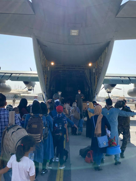 - 한국 정부와 협력한 아프가니스탄인들이 국내 이송을 위해 카불 공항에 도착한 한국 공군 수송기에 오르고 있다. 2021.8.25 외교부 제공