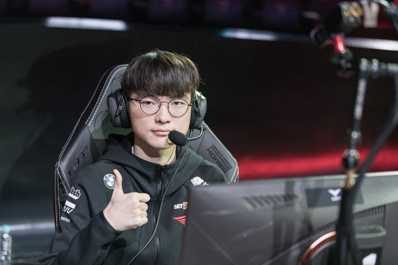 T1 mid laner Lee ″Faker″ Sang-hyeok holds his thumb up for the cameras while setting up to play at LoL Park. [RIOT GAMES]