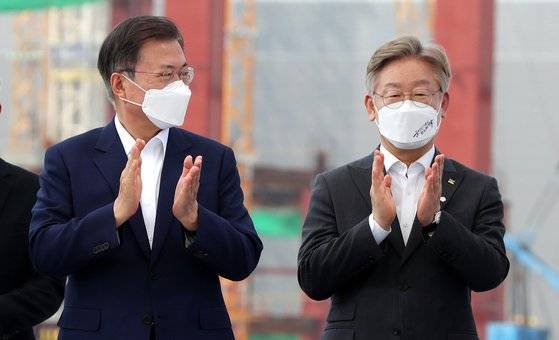 문재인 대통령이 5월 13일 오후 경기 평택시 삼성전자 평택단지 3라인 건설 현장에 마련된 야외무대에서 열린 'K-반도체 전략 보고'에서 '반도체 생태계 강화 연대 협력 협약식'을 마친 후 이재명 경기도지사와 박수치고 있다. 연합뉴스