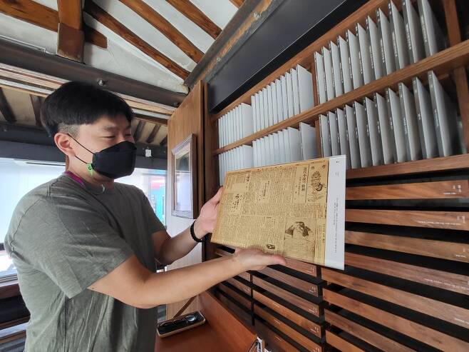 Lee Sang-hyun, who is in charge of publicity for the National Trust for Cultural Heritage, holds up a copy of one of Lee Sang’s works from 1934. (Kim Hae-yeon/The Korea Herald)