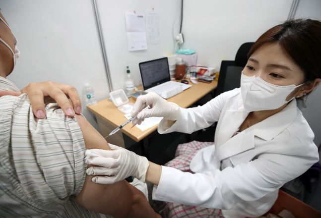 14일 오후 서울 영등포구 코로나19 예방접종센터에서 의료진이 시민에게 접종을 하고 있다.ⓒ뉴시스