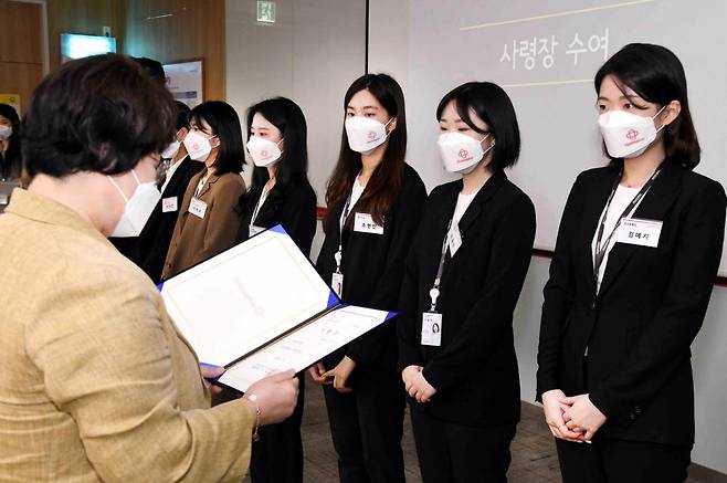 홈플러스 상반기 공개채용 인턴십 과정을 거쳐 최종 합격된 신입사원 24명이 지난 13일 서울 등촌동 홈플러스 본사 사옥에서 열린 사령식에서 황정희 홈플러스 인사부문장(좌측)으로부터 사령장을 수여받고 있다.