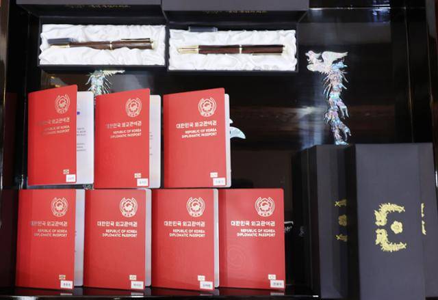 문재인 대통령이 14일 청와대에서 열린 미래세대와 문화를 위한 대통령 특별사절 임명장 수여식에서 그룹 방탄소년단(BTS)에게 임명장을 수여했다. 사진은 이날 BTS 멤버들에게 전해진 외교관 여권과 기념품(만년필). 뉴시스