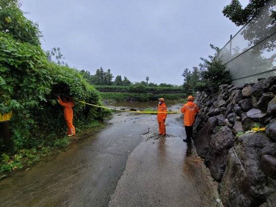 진입통제선 설치하는 소방대원들 (제주=연합뉴스) 태풍 찬투의 간접 영향으로 제주에 많은 비가 내린 14일 제주시 화북천 범람으로 길이 물에 잠기자 소방대원들이 출입 통제선을 설치하고 있다.연합뉴스