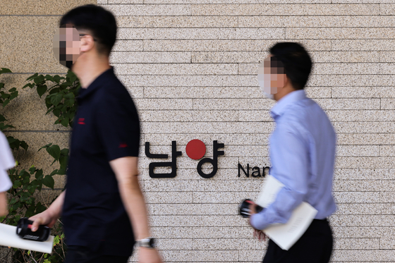 Namyang Dairy Products shareholders leave the building following an extraordinary shareholders’ meeting held at the company headquarters in Gangnam, southern Seoul, on Tuesday. [YONHAP]