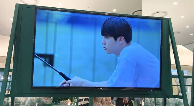 A scene from BTS’ version of “In the Soop” shows bandmate Jin fishing in the woods. (Park Jun-hee/The Korea Herald)