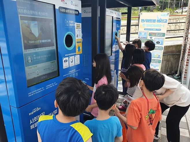자판기 형태의 순환자원 회수로봇 앞에서 어린이들이 체험해 보고 있다. 전주시 제공