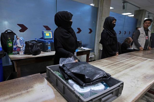 12일 아프가니스탄 카불 국제공항에서 여성 직원들이 눈을 제외한 전신을 검은 옷으로 가린 니캅을 착용한 채 근무하고 있다. 카불=AFP 연합뉴스