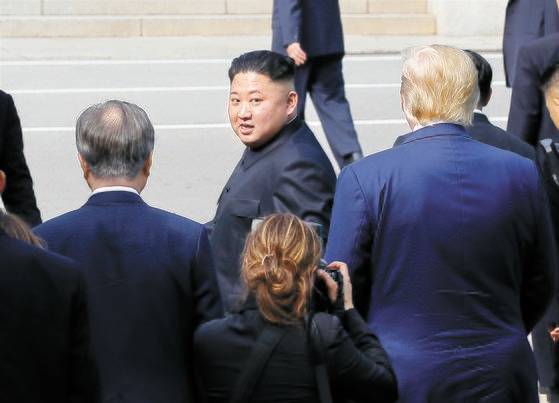 북한 김정은 국무위원장이 2019년 6월 30일 판문점에서 문재인 대통령과 도널드 트럼프 당시 미국 대통령의 배웅을 받으며 군사분계선을 넘어 북측으로 돌아가다 뒤돌아보고 있다. 연합뉴스