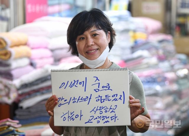 서울 종로구 광장시장에서 근무 중인 최영미 씨가 지난 7일 딸에게 보내는 메시지를 들고 있다.