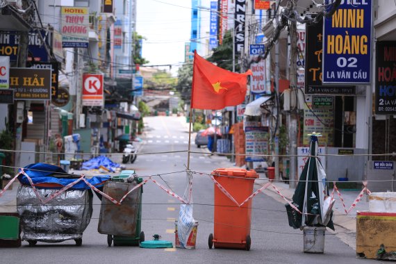 베트남 도시 절반 이상에 봉쇄령이 내려진 가운데 13일(현지시간) 붕타우의 한 상가 도로가 쓰레기통과 카트 등으로 만들어진 바리케이드로 봉쇄돼 있다. AP뉴시스