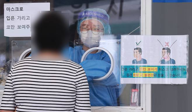 19일 서울역 중구 신종 코로나바이러스 감염증(코로나19) 임시선별검사소에서 의료진이 검체 채취를 하고 있다. [연합]