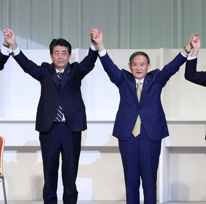 아베 신조 전 총리(왼쪽)가 지난해 9월14일 자민당 총재로 뽑힌 스가 요시히데 총리(오른쪽)를 축하하고 있다(사진=AFP)