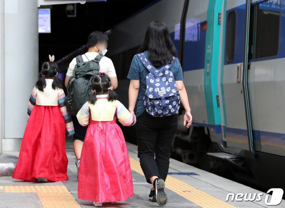 추석 연휴 둘째 날인 19일 오전 서울역에서 한복을 곱게 입은 아이들이 부모와 함께 귀성열차로 향하고 있다. [뉴스1]
