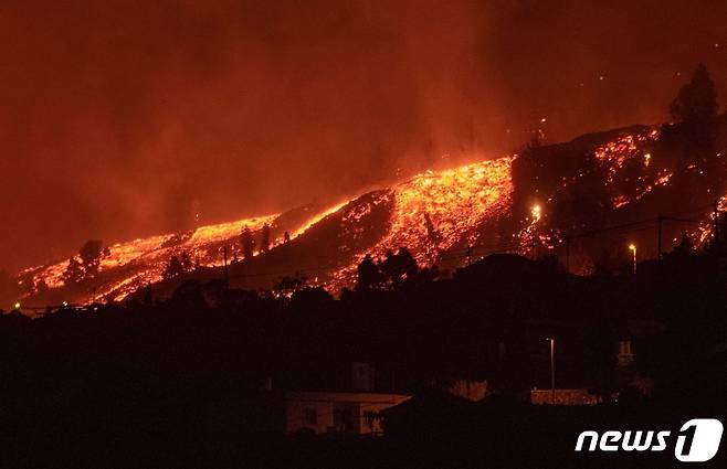 19일 오후 (현지시간) 북아프리카 서쪽 스페인령 카나리아제도의 라팔마섬 쿰브레 비에하 국립공원 ‘카베사 데 바카’ 구역 내 화산이 분화했다. 당국은 이 화산이 일주일간의 지진 활동 끝에 폭발해 분출된 용암이 가옥을 파괴하고 해안으로 접근하면서 수천 명의 주민에 대피령을 내렸다고 밝혔다. © AFP=뉴스1