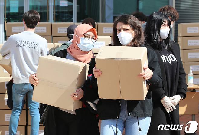 (대구=뉴스1) 공정식 기자 = 지난해 3월 16일 오후 대구 계명대학교 성서캠퍼스에서 열린 신종 코로나바이러스 감염증(코로나19) 확산에 따른 국내 거주 외국인 유학생 식품 지원 행사에서 외국인 유학생들이 구호물품을 받아 기숙사로 향하고 있다. 2020.3.16/뉴스1