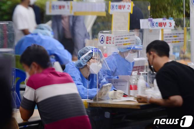 지난 4일 오후 광주 광산구보건소 선별진료소에서 의료진들이 시민들에게 문진표 작성을 안내하고 있다. /뉴스1 DB © News1