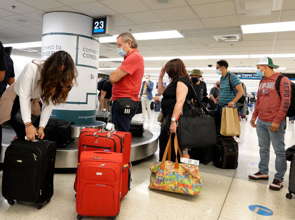 20일(현지시간) 마이애미 국제공항에서 여행객들이 자신의 짐을 찾고 있다. 마이애미=AFP연합