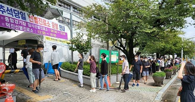 한가위 당일인 21일 전북 전주시 덕진 선별진료소에서 시민들이 신종 코로나바이러스 감염증(코로나19) 진단 검사를 받기 위해 줄을 서 기다리고 있다. 전주=뉴스1