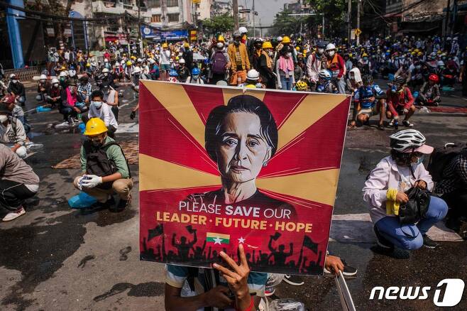 2일(현지시간) 미얀마 양곤에서 군부 쿠데타 규탄 시위대가 아웅산 수치의 사진을 들고 경찰의 진압을 대비하고 있다. © AFP=뉴스1 © News1 우동명 기자