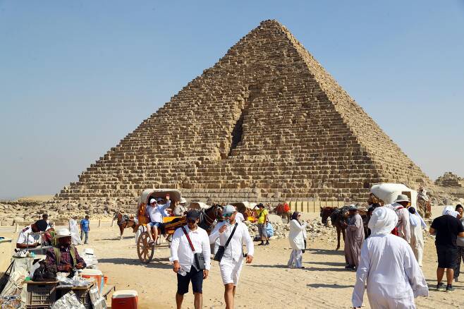 지난 7월 이집트 기자를 찾은 관광객들이 피라미드를 둘러보고 있다. 이집트 관광진흥청은 신종코로나바이러스감염증(코로나19) 봉쇄 조치와 여행제한을 해제하는 국가들이 늘어나면서 관광 부문이 40%가량 회복했다고 밝혔다./연합뉴스
