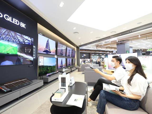 롯데하이마트 대치점에서 모델들이 대형 TV로 콘텐츠를 감상하고 있다. 롯데하이마트 제공