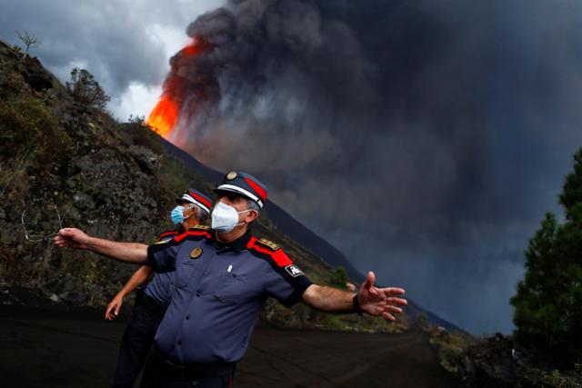 스페인령 카나리아제도 라 팔마섬의 쿰브레 비에하 국립공원 '카베사 데 바카' 구역 화산이 분화를 시작한 가운데 22일 경찰들이 도로를 봉쇄하고 있다. 라 팔마=로이터 연합뉴스