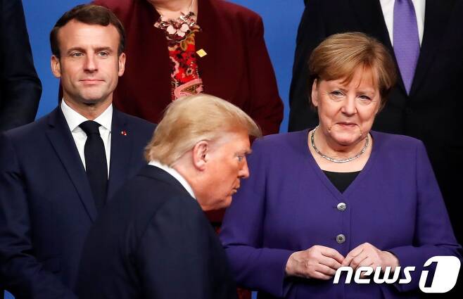 에마뉘엘 마크롱 프랑스 대통령과 앙겔라 메르켈 독일 총리가 2019년 12월 4일(현지시간) 런던 외곽 왓퍼드의 그로브 호텔에서 나토 창설 70주년 기념 정상회의 단체사진을 찍기위해 지나가는 도널드 트럼프 미국 대통령을 바라보고 있다. © AFP=뉴스1 © News1 우동명 기자