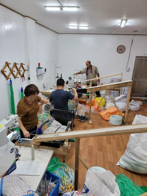 남양어망 공장에서 김 대표와 직원들이 맞춤형 제작 그물에 부자와 납(봉돌)을 부착하고 있다. 목포= 박경우 기자