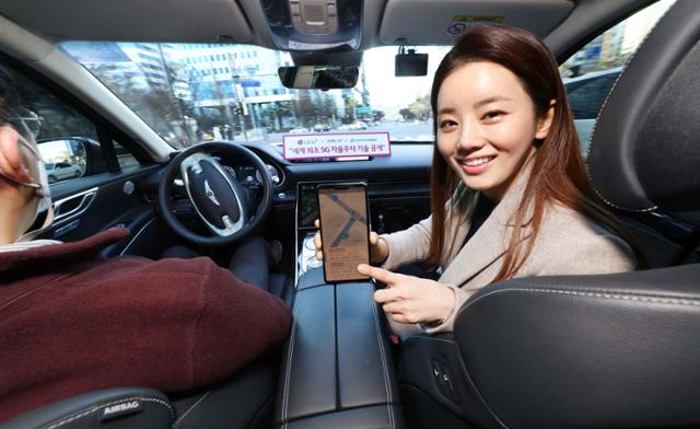 LG유플러스 모델이 서울시 상암 5G 자율주행 시범지구에서 모바일 앱으로 5G 자율주행차 'A1(에이원)'을 인근 주차장으로 보내는 모습. LG유플러스 제공