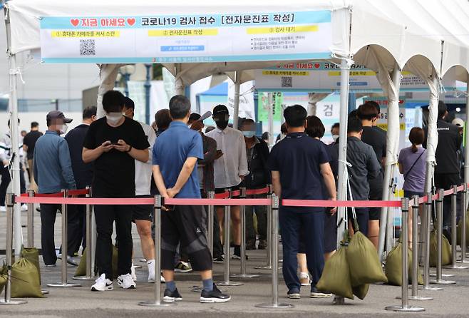 지난 25일 오전 서울역 광장에 마련된 중구임시선별검사소에서 시민들이 검사를 받기 위해 기다리고 있다. 연합뉴스