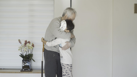 Kim Tschang-yeul hugs his grandson in "The Man Who Paints Water Drops." [MIRU PICTURES]