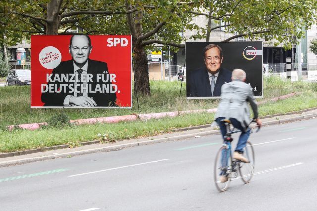 독일 시민이 26일(현지시간) 총선 후보들의 광고판이 설치된 베를린의 한 거리에서 자전거를 타고 지나가고 있다. 16년 동안 장기집권한 앙겔라 메르켈 독일 총리의 뒤를 이을 후보가 이날 총선으로 선출될 예정이다. 신화연합뉴스
