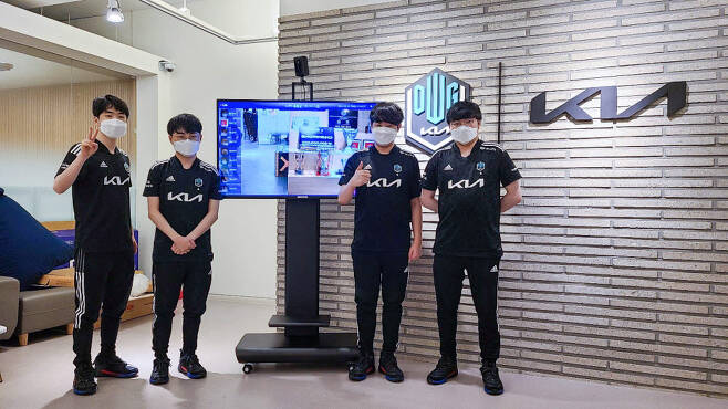 담원기아 선수들이 씨유이(CUE)그룹이 기증한 인공지능(AI) 열화상 관제시스템 앞에서 승리 기원 포즈를 취하고 있다.