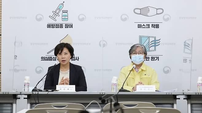 The head of the national advisory committee on immunization practices Dr. Choi Eun-hwa (left) speaks during Monday's news briefing. She removed her mask briefly while she spoke. On the right is Jeong Eun-kyeong, the Korea Disease Control and Prevention Agency's Commissioner. (Yonhap)