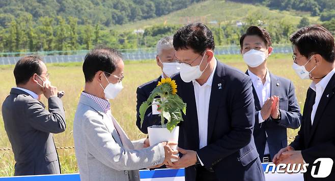 송영길 더불어민주당 대표가 15일 세종시 국회세종의사당 예정 후보지를 방문해 현장을 둘러본 뒤 국회 이전을 희망하는 지역민에게 해바라기를 받고 있다. 2021.7.15/뉴스1 © News1 장수영 기자