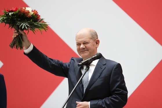독일 사회민주당 총리후보 올라프 숄츠가 총선 승리를 기념하며 지지자들에게 꽃다발을 들어보이고 있다. 연합뉴스
