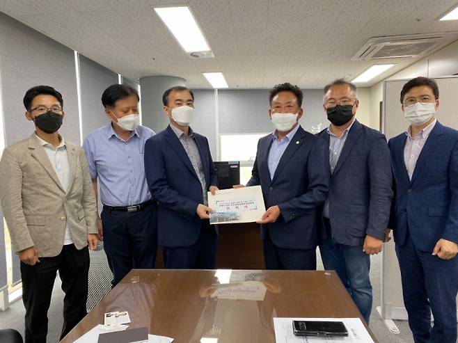 28일 백강훈 지진특위 위원장(오른쪽 세번째)과 배상신 부위원장이 국무조정실을 찾아 피해 구제 등의 내용이 담긴 건의서를 전달하고 있다. (포항시의회 제공) 2021.09.28