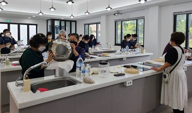 탄산막걸리 만들기 체험 프로그램 참가자들이 지난 24일 모명재 한국전통문화체험관에서 막걸리를 만들기 위해 고두밥을 찌고 있다. (수성구 제공) 2021.09.28